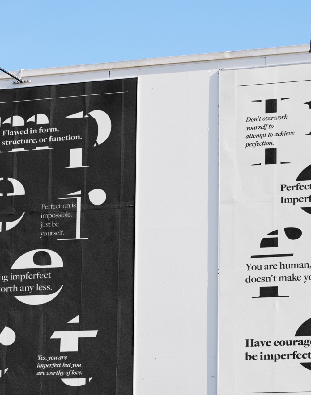 Close up of a mockup of two posters of expressive type, one in black, and one and inverted version of the first.